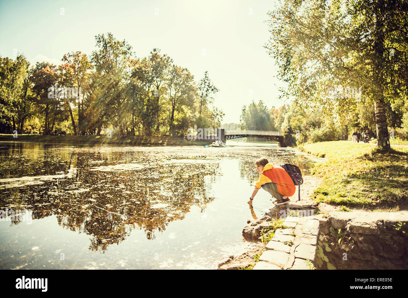 Kaukasische Frau Eintauchen der Hand im Park Teich Stockfoto