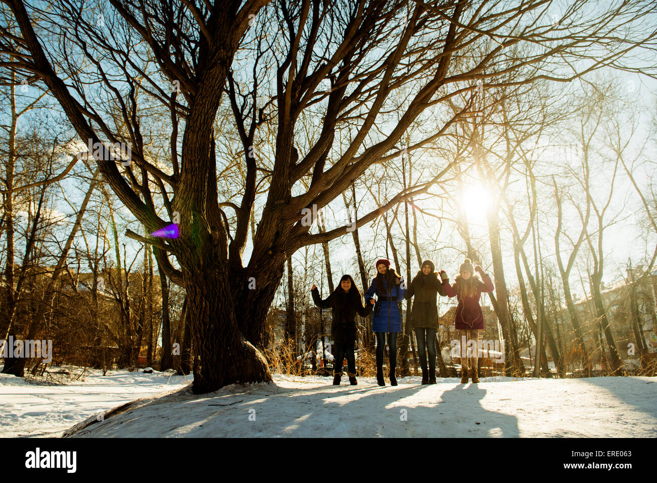 Kaukasische Mädchen stehen ordentlich Baum in schneebedecktes Feld Stockfoto