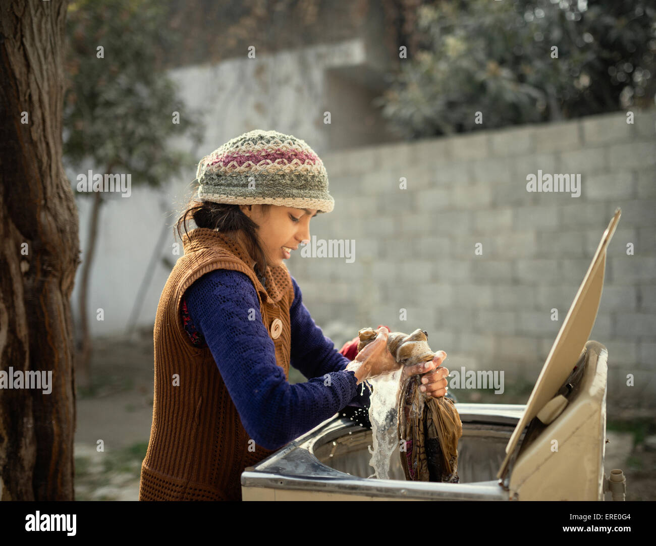 Frau in Strick Mütze von Hand waschen Kleidung im freien Stockfoto