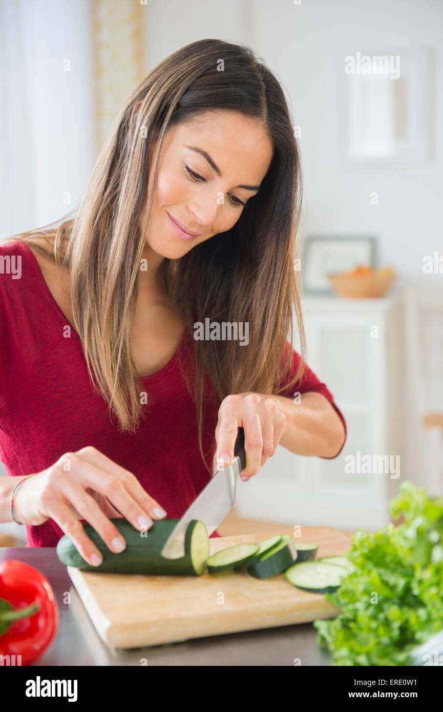 Kaukasische Frau schneiden Gemüse für Salat Stockfoto
