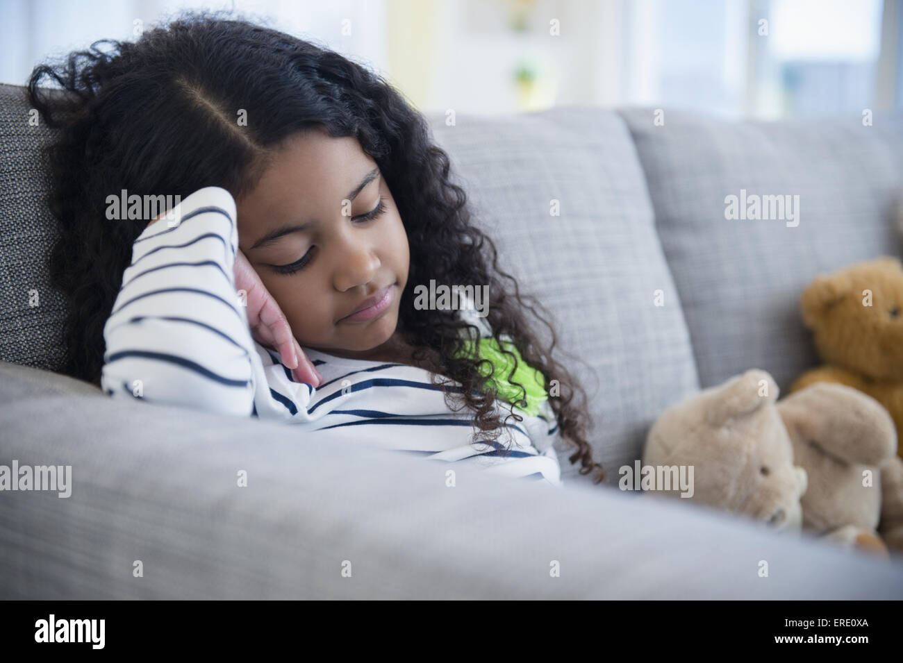 Trauriges Gemischte Rassen Mädchen sitzen auf sofa Stockfoto