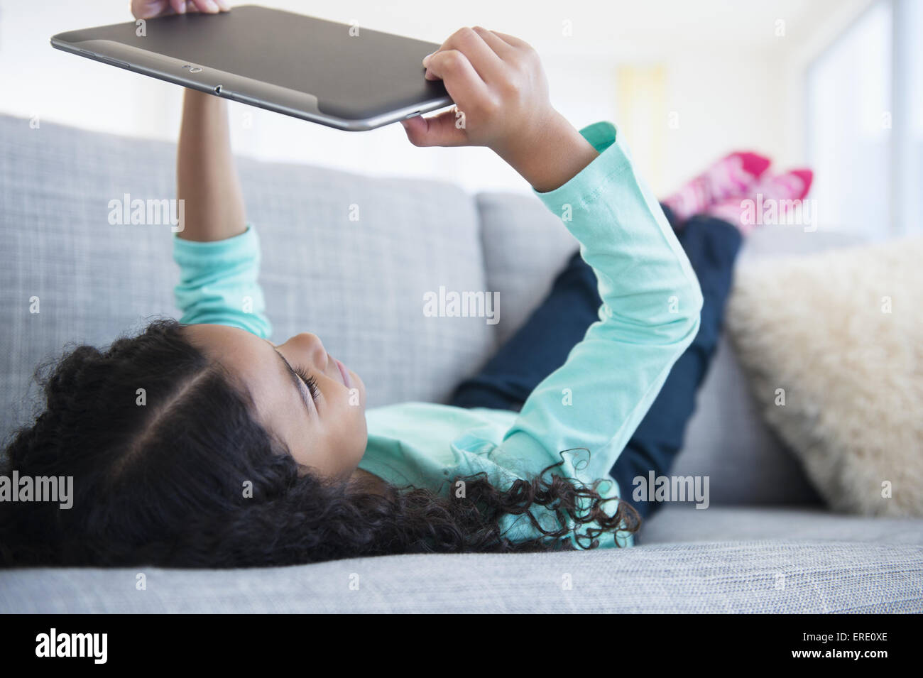 Gemischte Rassen Mädchen mit digital-Tablette auf sofa Stockfoto