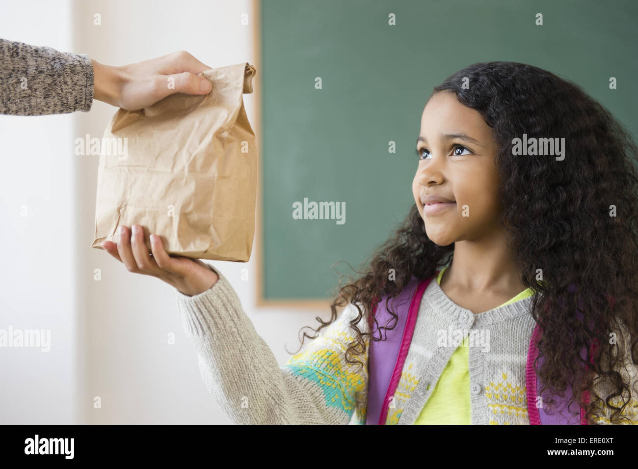 Schüler nehmen braune Tasche Mittagessen im Klassenzimmer Stockfoto