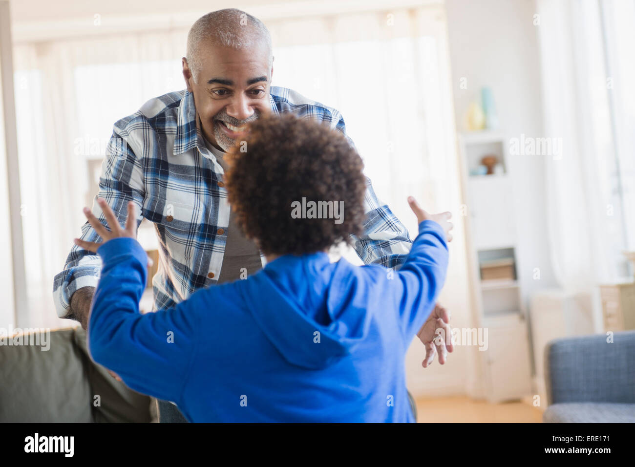 Gemischte Rassen Großvater und Enkel Gruß im Wohnzimmer Stockfoto
