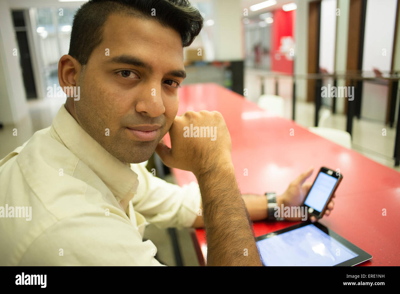 Asiatische Geschäftsmann mit Handy und digital-Tablette in office Stockfoto