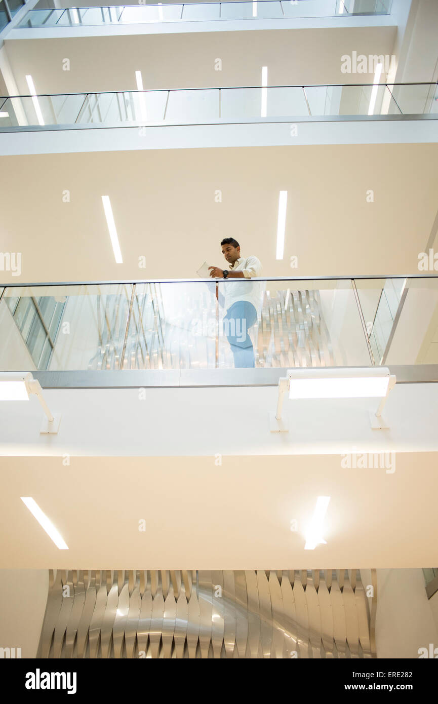 Asiatische Geschäftsmann stehend auf Balkon des Bürogebäudes Stockfoto