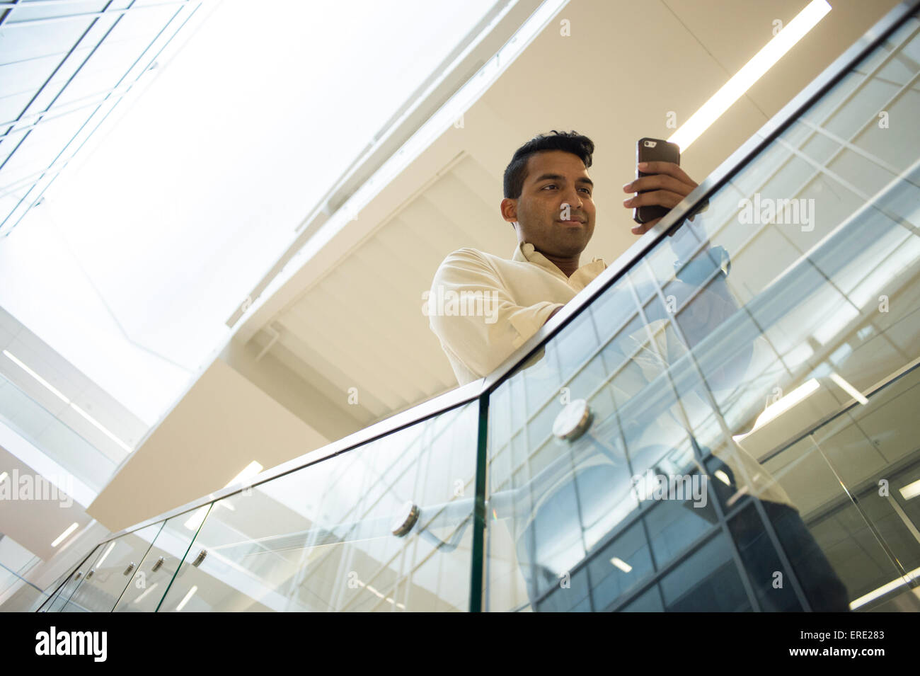 Asiatische Geschäftsmann SMS mit Handy auf Büro-Treppe Stockfoto