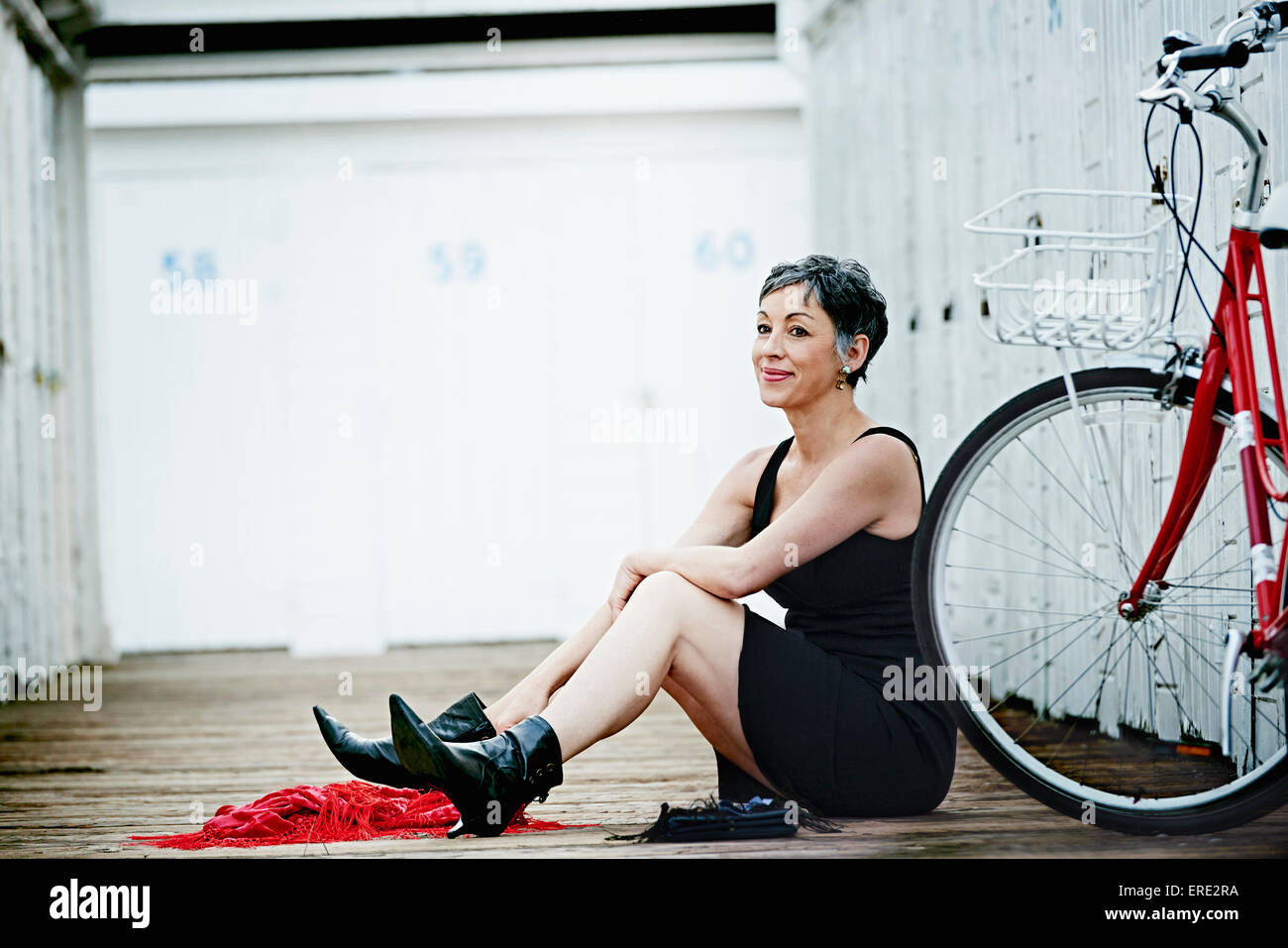 Ältere Frau kaukasischen sitzen mit dem Fahrrad auf hölzerne dock Stockfoto