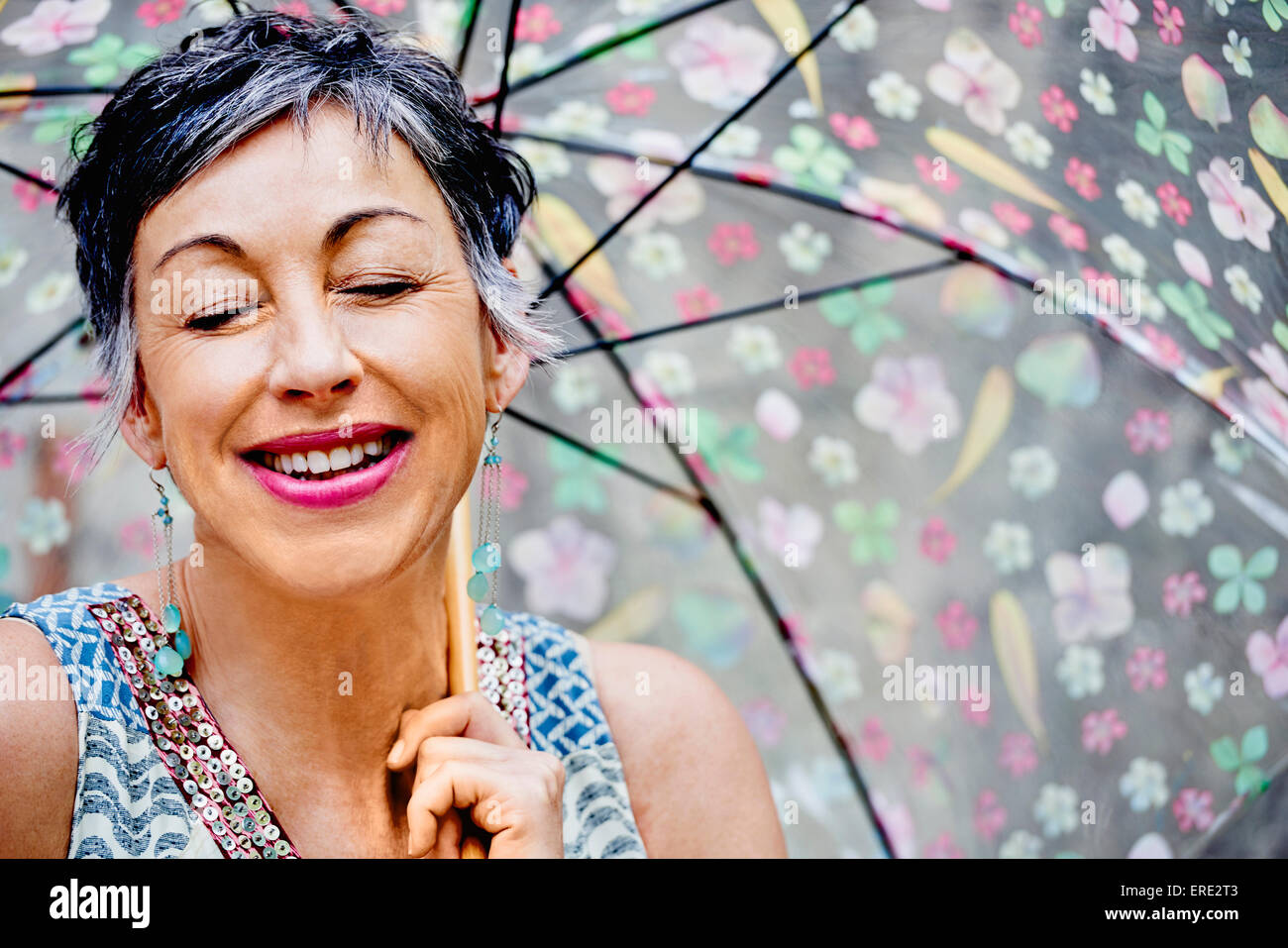 Ältere Frau kaukasischen mit Augen geschlossen halten Regenschirm Stockfoto