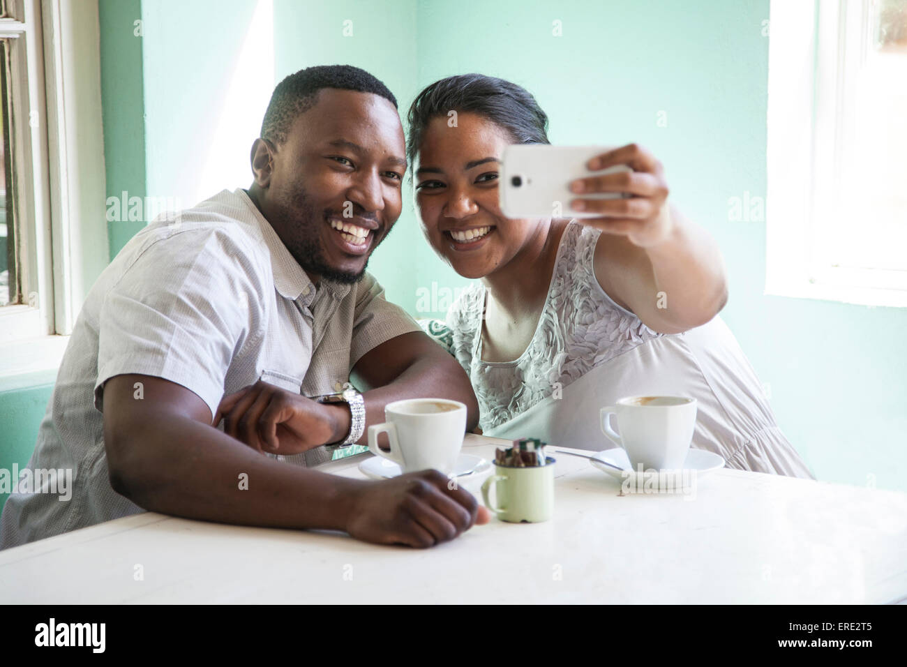Lächelnde paar unter Handy Selfie am Tisch Stockfoto