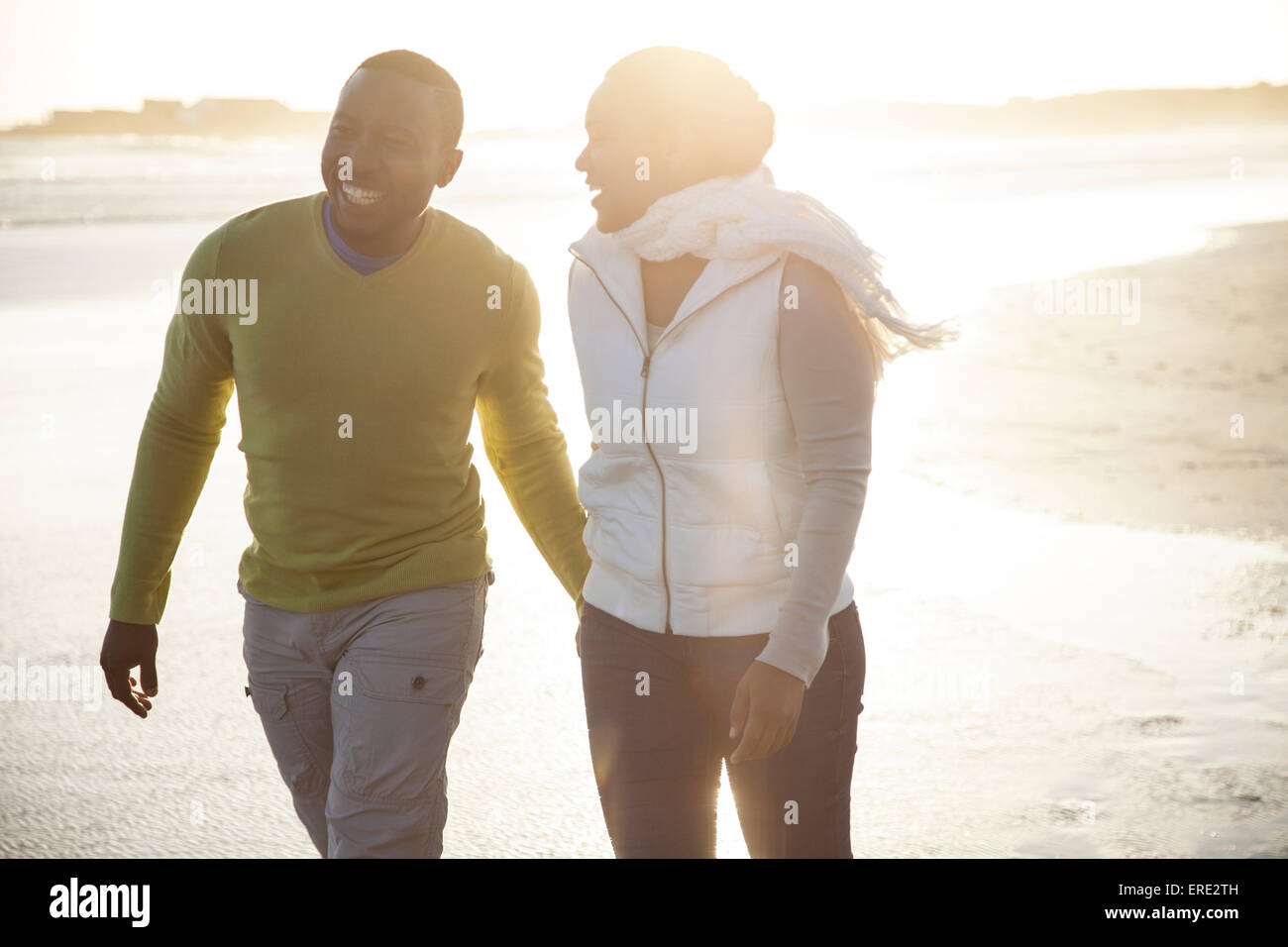 Lächelnde paar zu Fuß am Strand Stockfoto