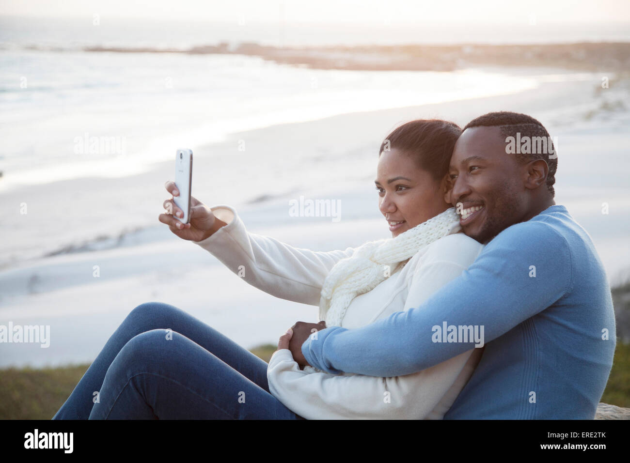 Lächelnde paar unter Handy Selfie am Strand Stockfoto