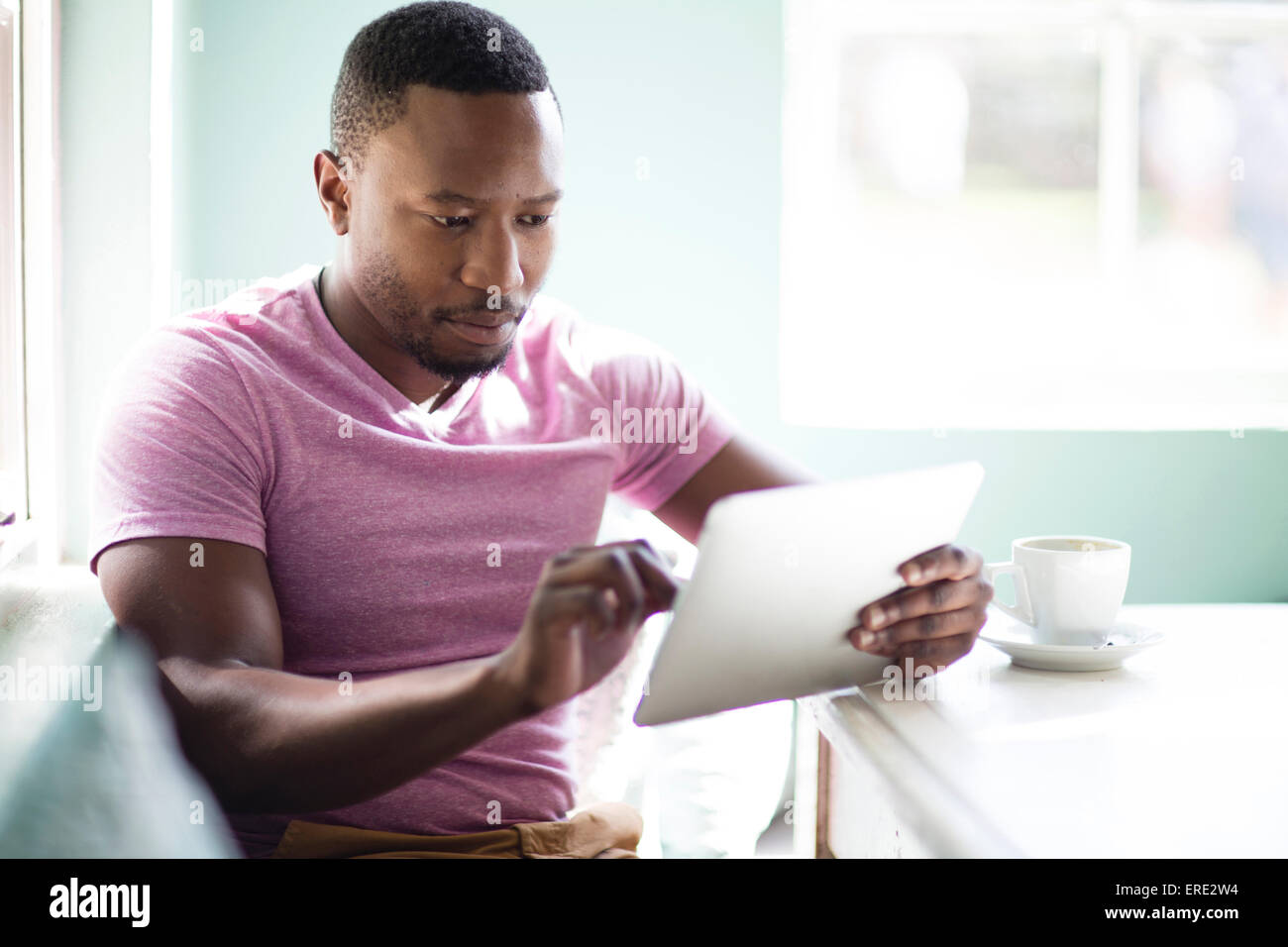 Schwarzer Mann mit digital-Tablette zum Frühstück Stockfoto