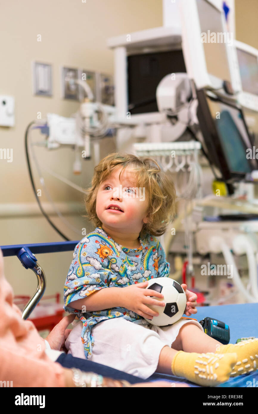 Kaukasische Junge saß am Krankenhausbett mit Fußball Stockfoto