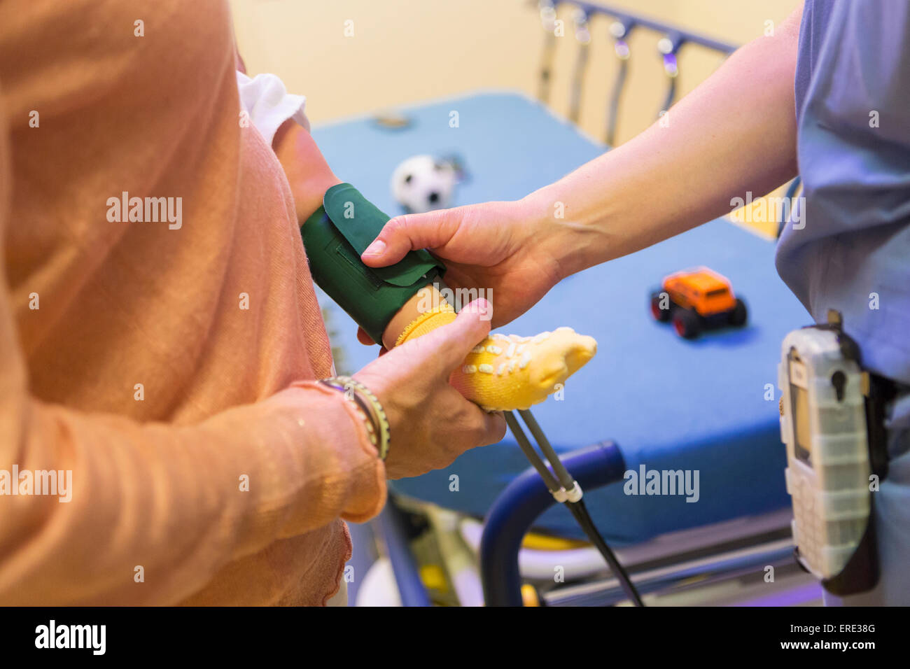 Messung Blutdruck am Bein des jungen Arzt Stockfoto