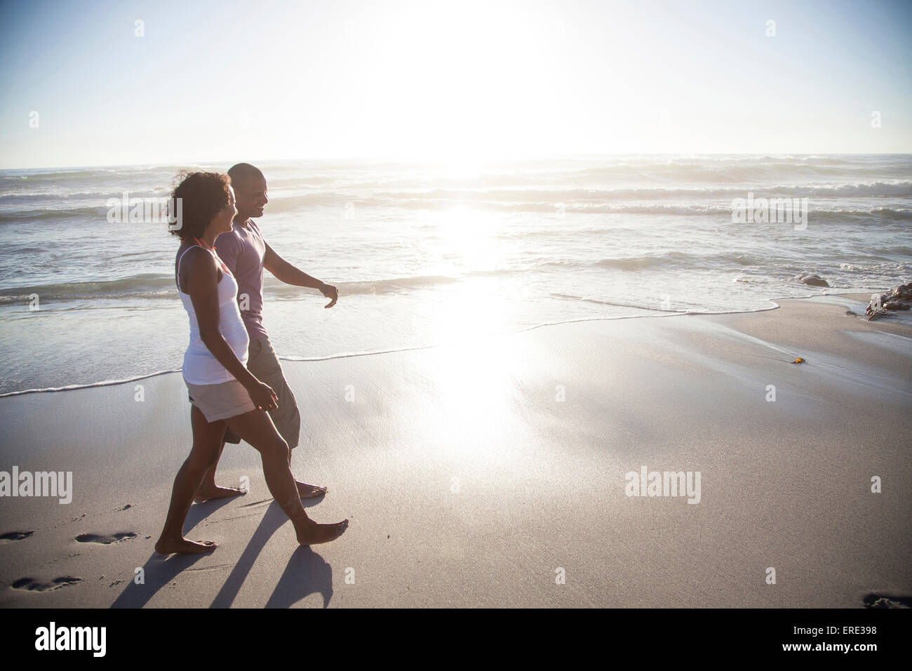 Gemischte Rassen paar zu Fuß am Strand Stockfoto