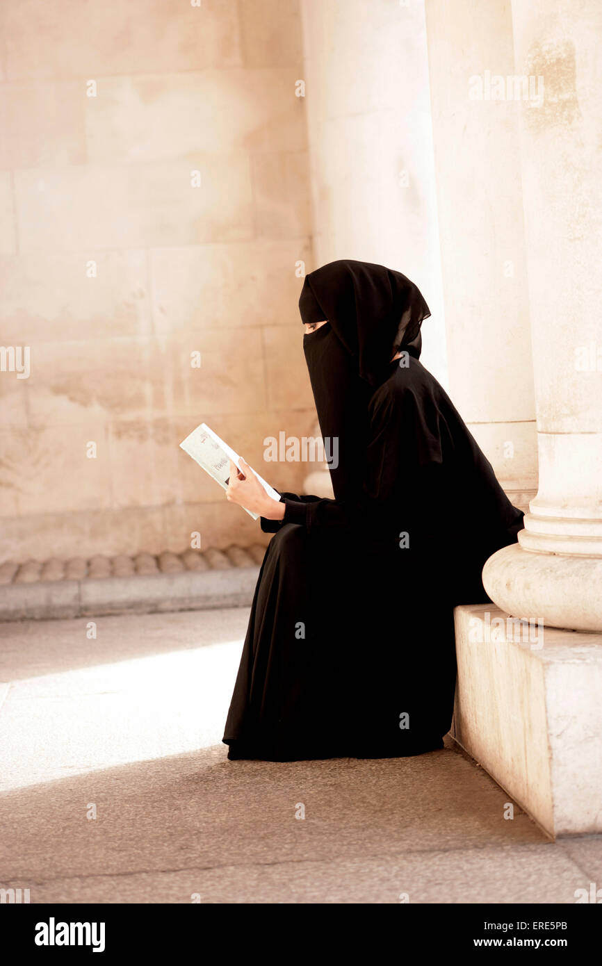 Alle ANWENDUNGEN, DIE SICH AUS MODELL muslimische Frau das Tragen einer Burka, lesen Sie ein Buch in englischer Sprache und Pakistanischen geschrieben. Stockfoto