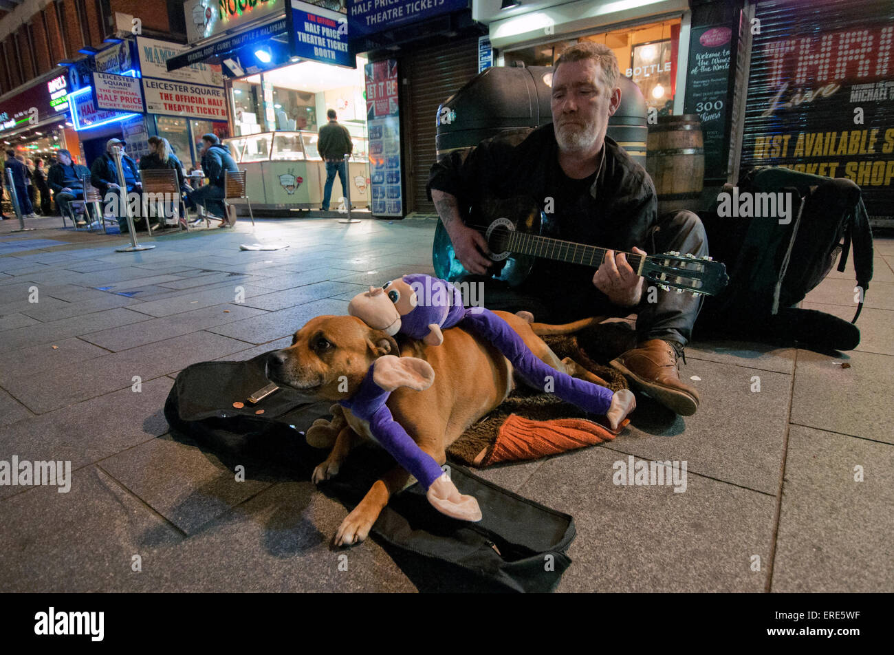 Obdachlosen Mann als Straßenmusikant und Gitarre in Soho mit seinem Hund zu spielen. Stockfoto