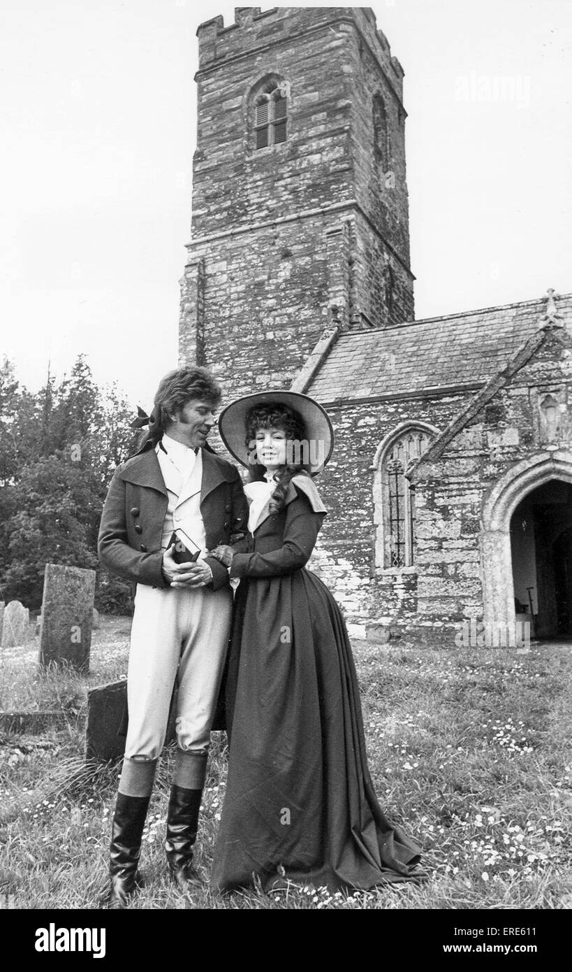 Robin Ellis Ross Poldark sowie Angharad Rees als Demelza außerhalb St. Winnows Kirche in der Nähe von Lostwithiel, Cornwall während der Dreharbeiten Poldark im Mai 1977. Stockfoto