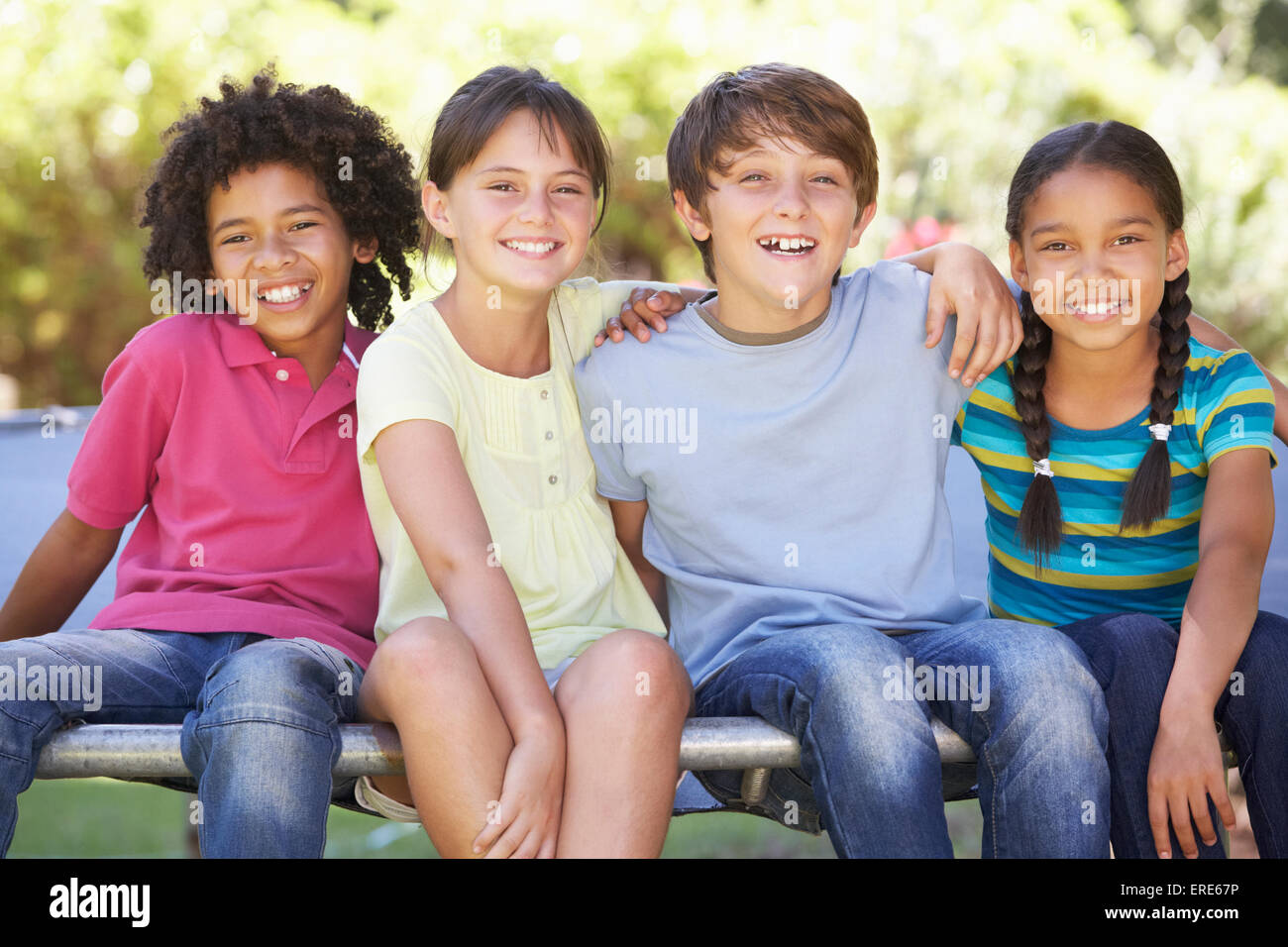Gruppe von Kindern zusammensitzen am Rand des Trampolin Stockfoto