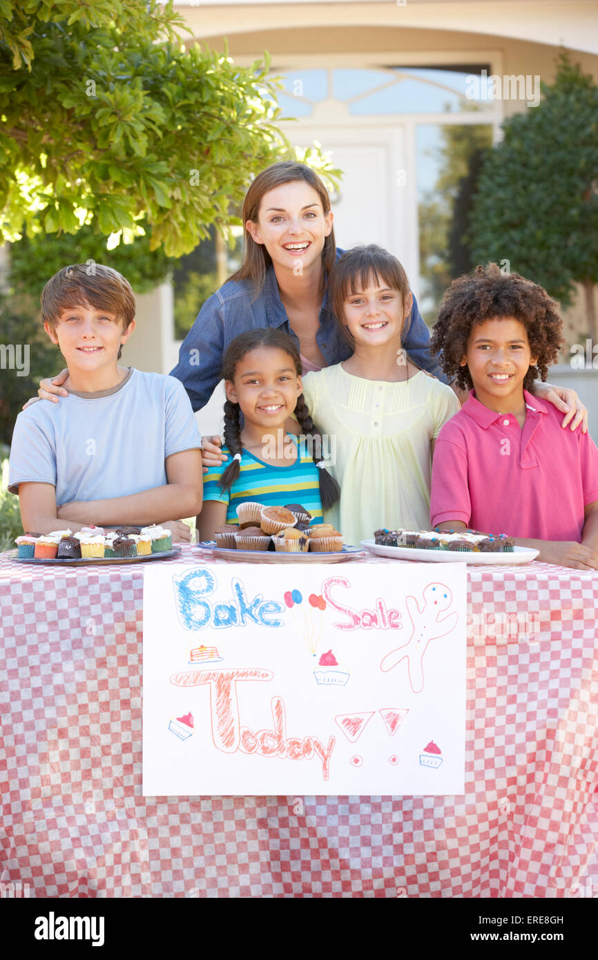 Gruppe von Kindern mit Kuchenverkauf mit Mutter Stockfoto