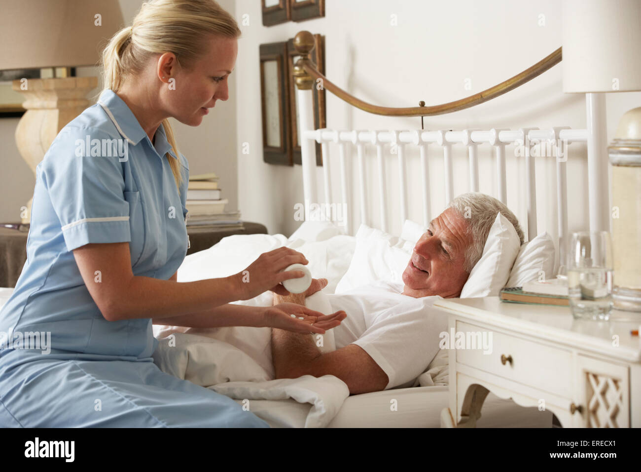 Krankenschwester Senior männlichen Medikamente zu Hause im Bett zu geben Stockfoto