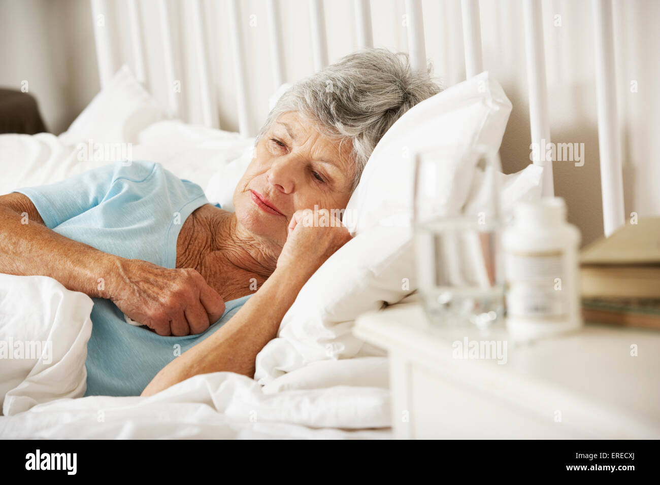 Medikamente auf Nachttisch schlaflose Senior Frau Stockfoto