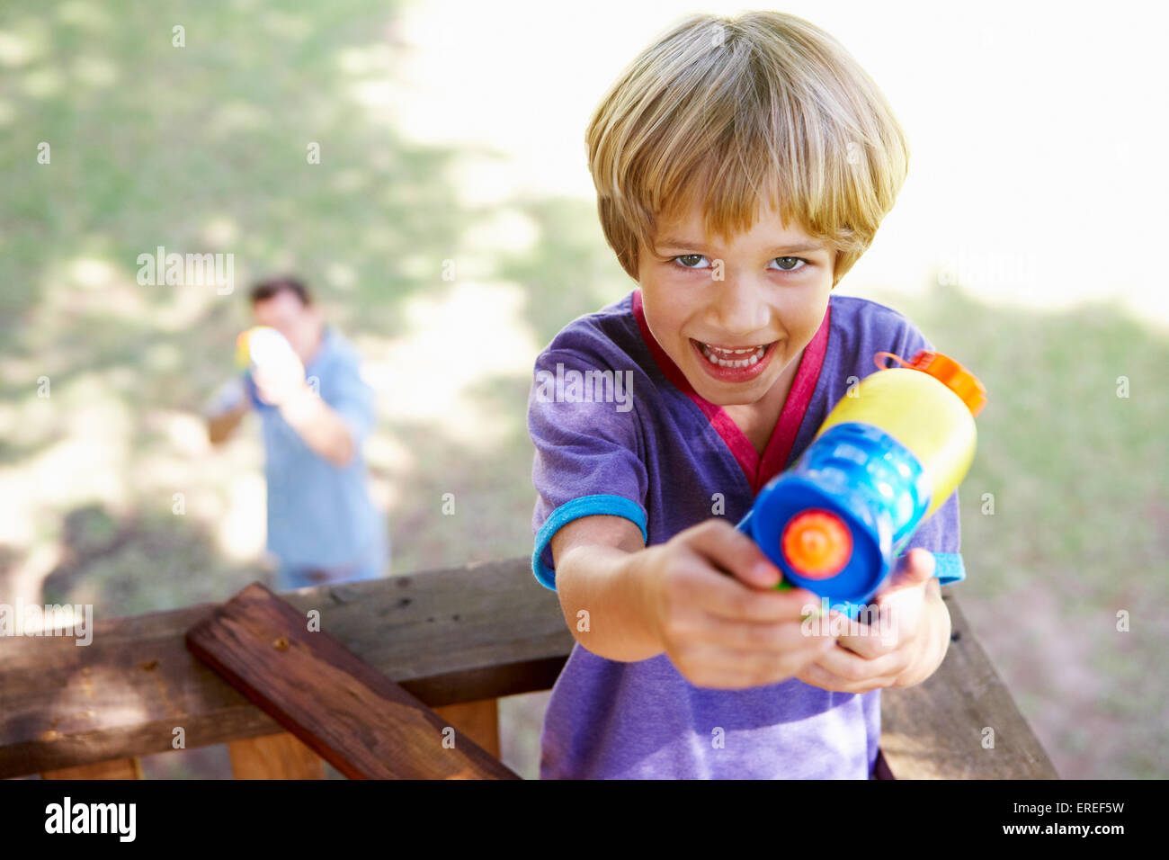 Vater und Sohn mit Wasserpistole Kampf im Baumhaus Stockfoto