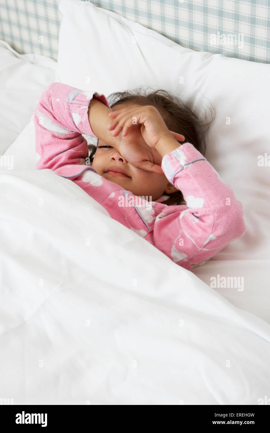 Müde Mädchen Pyjama im Bett tragen Stockfoto