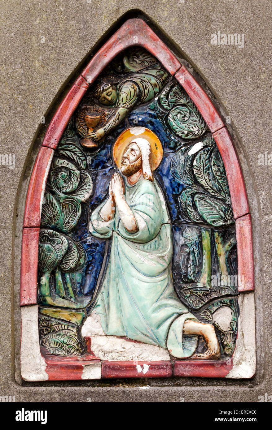 Nahaufnahme eines Christen, malte Gedenkstein auf einem Grabstein in Brompton Cemetery. Zeigt die kniende Gestalt Jesu. Stockfoto