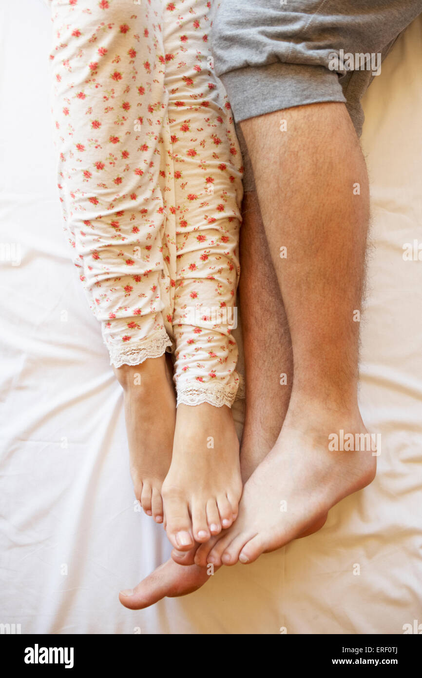Detail des Paares Beine entspannend im Bett Stockfoto