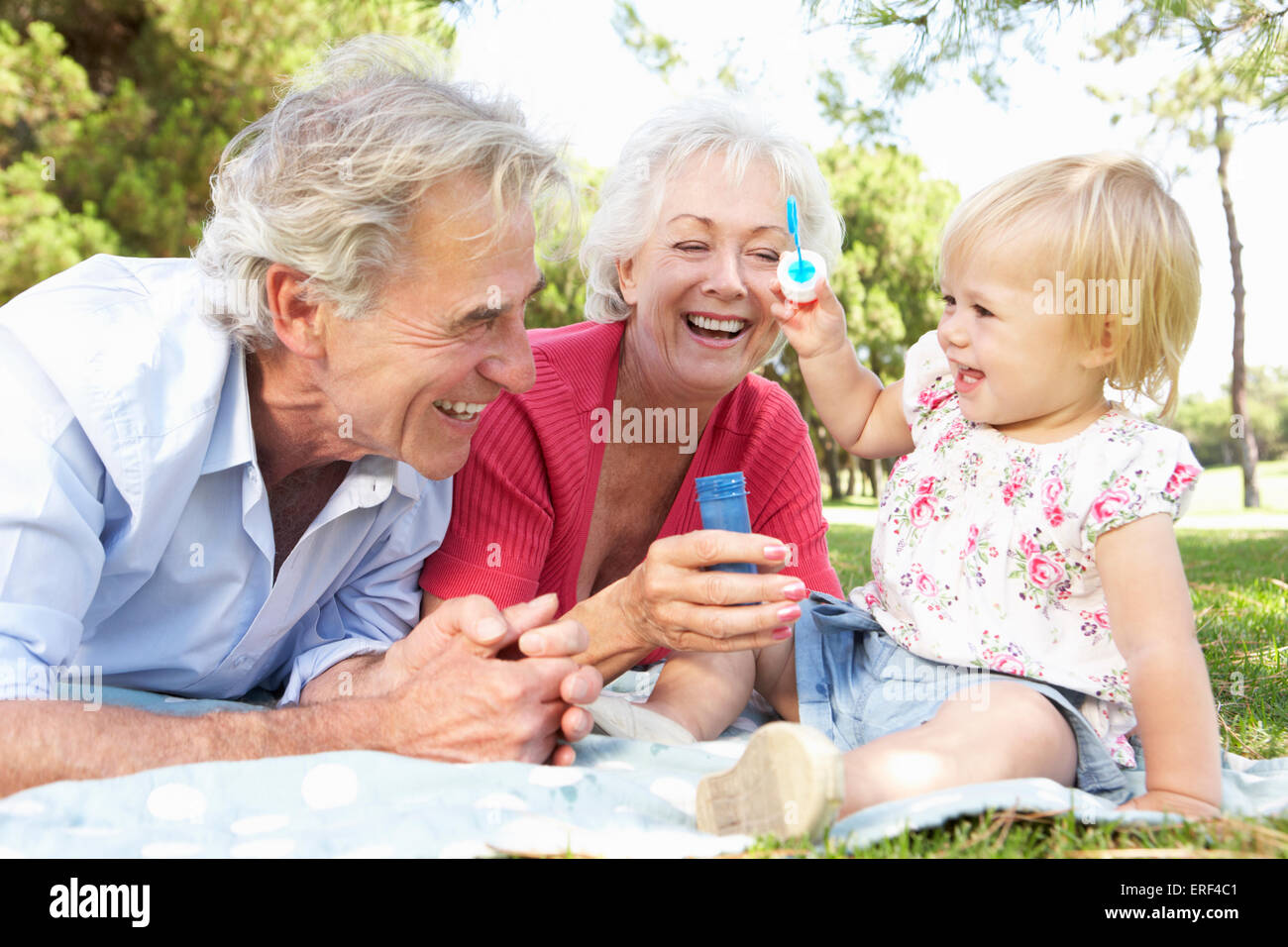 Großeltern und Enkeltochter zusammen im Park spielen Stockfoto