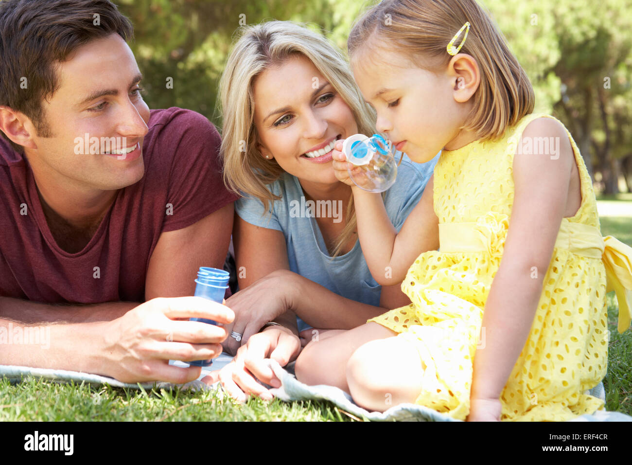 Familie im Garten spielen und Seifenblasen Stockfoto