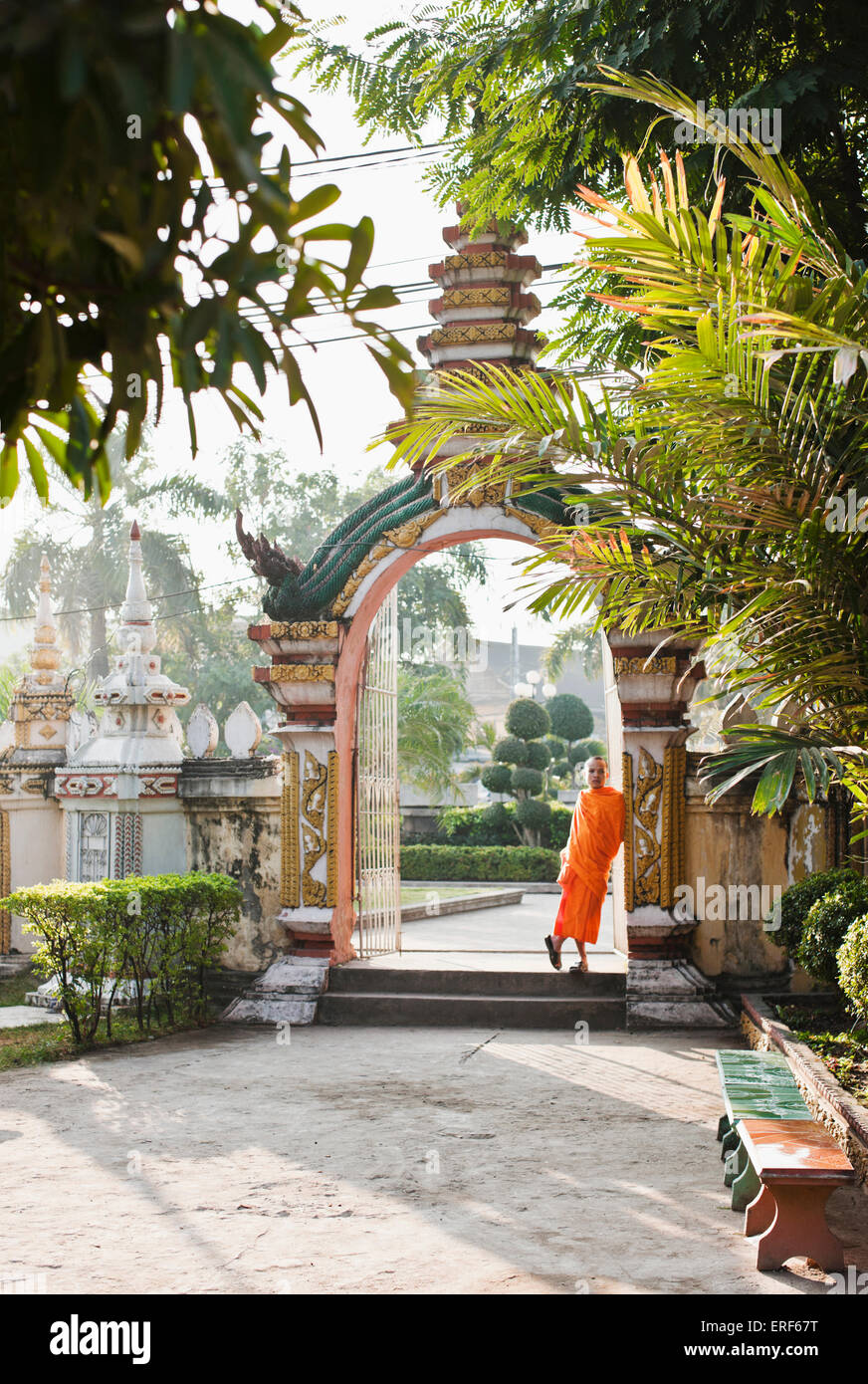 Ein junger Mönch entspannt in einem Hauseingang in Wat Si Muang, Vientiane, Laos, P.D.R Wat Si Muang ist ein buddhistischer Tempel, berühmt für die Erhebung Stockfoto