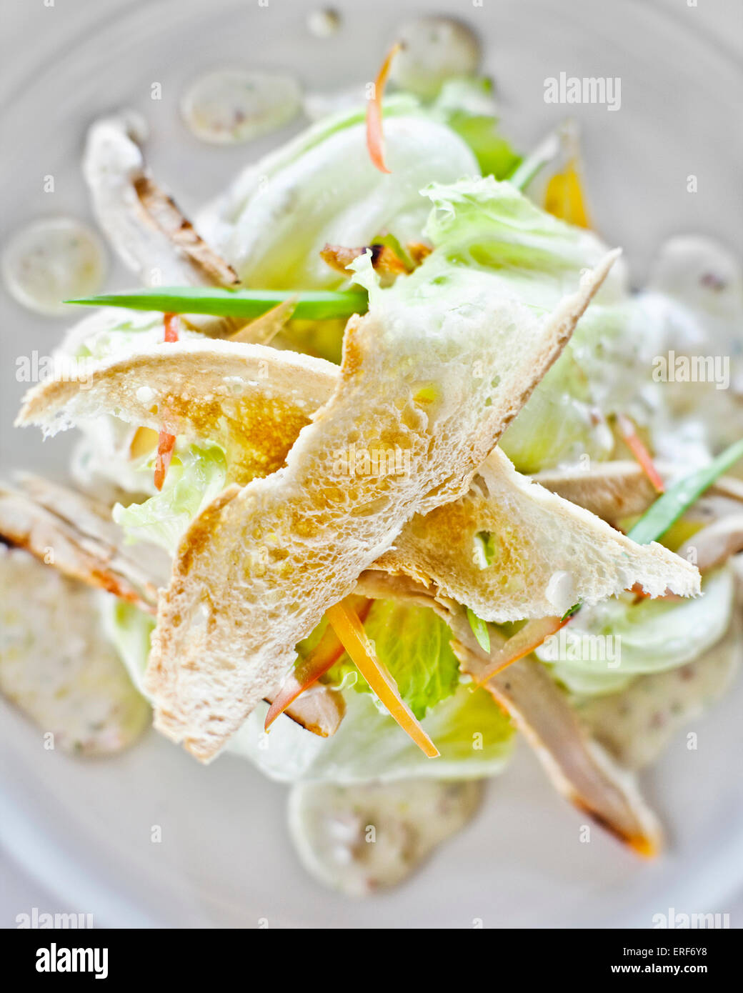 Klassischer Caesar-Salat mit Knoblauch-Parmesan-Sahne-Sauce begleitet von Huhn Angebote und gerösteten französischen Baguettes geworfen. Stockfoto