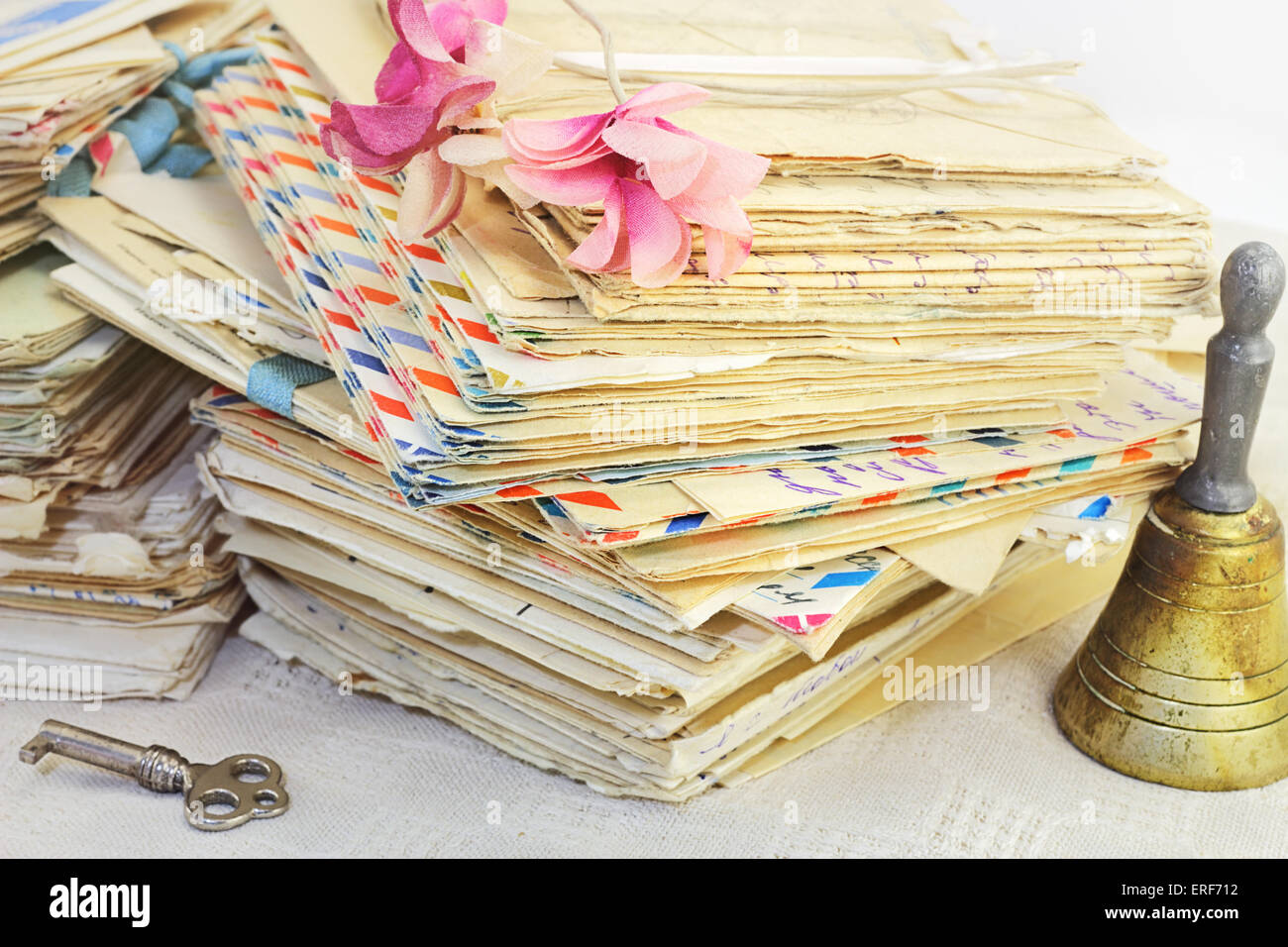 Die Erinnerung an die Vergangenheit. Stapelt der alten Briefe, Vintage Kunstblumen, Schlüssel und Glocke. Stockfoto