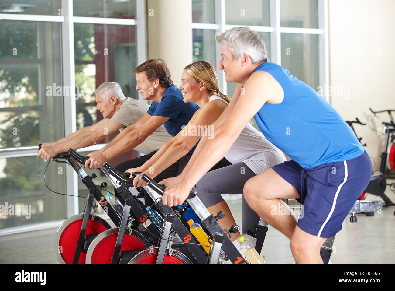 Spinning-Klasse mit vier glückliche ältere Leute in ein Fitness-Studio Stockfoto