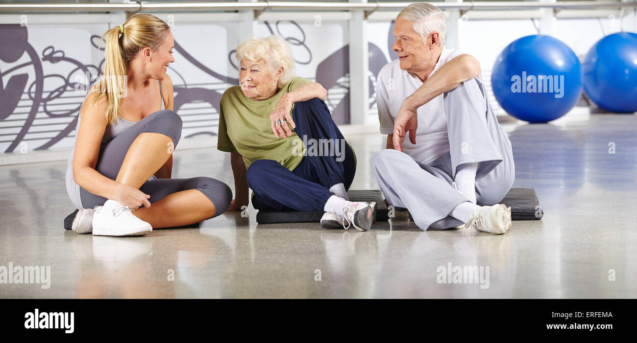 Ältere Menschen, die zu brechen, im Fitness-Studio und miteinander zu reden Stockfoto