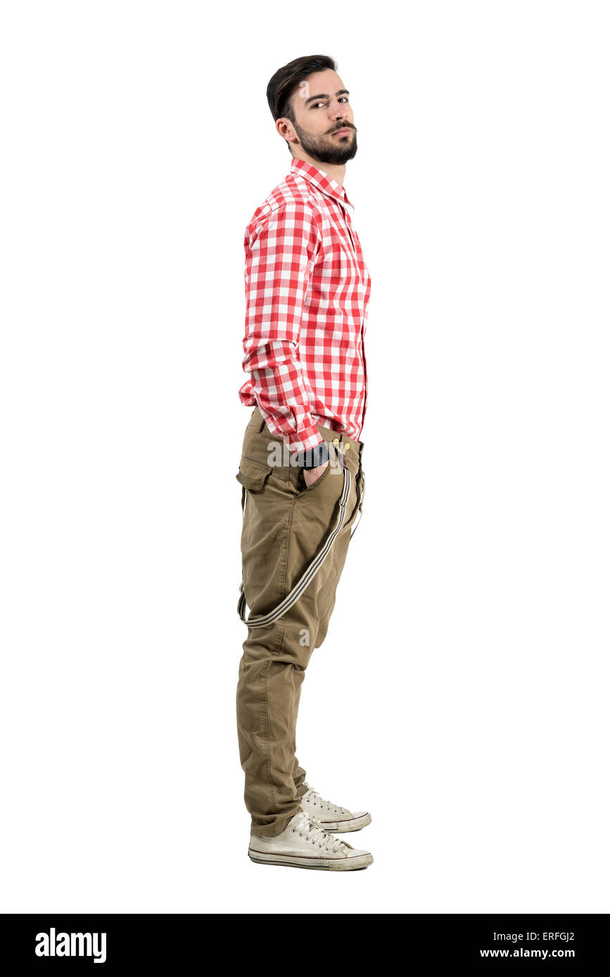 Young zuversichtlich bärtige Hipster Seitenansicht mit Händen in den Taschen. Ganzkörper-Länge-Porträt isoliert auf weißem Hintergrund. Stockfoto