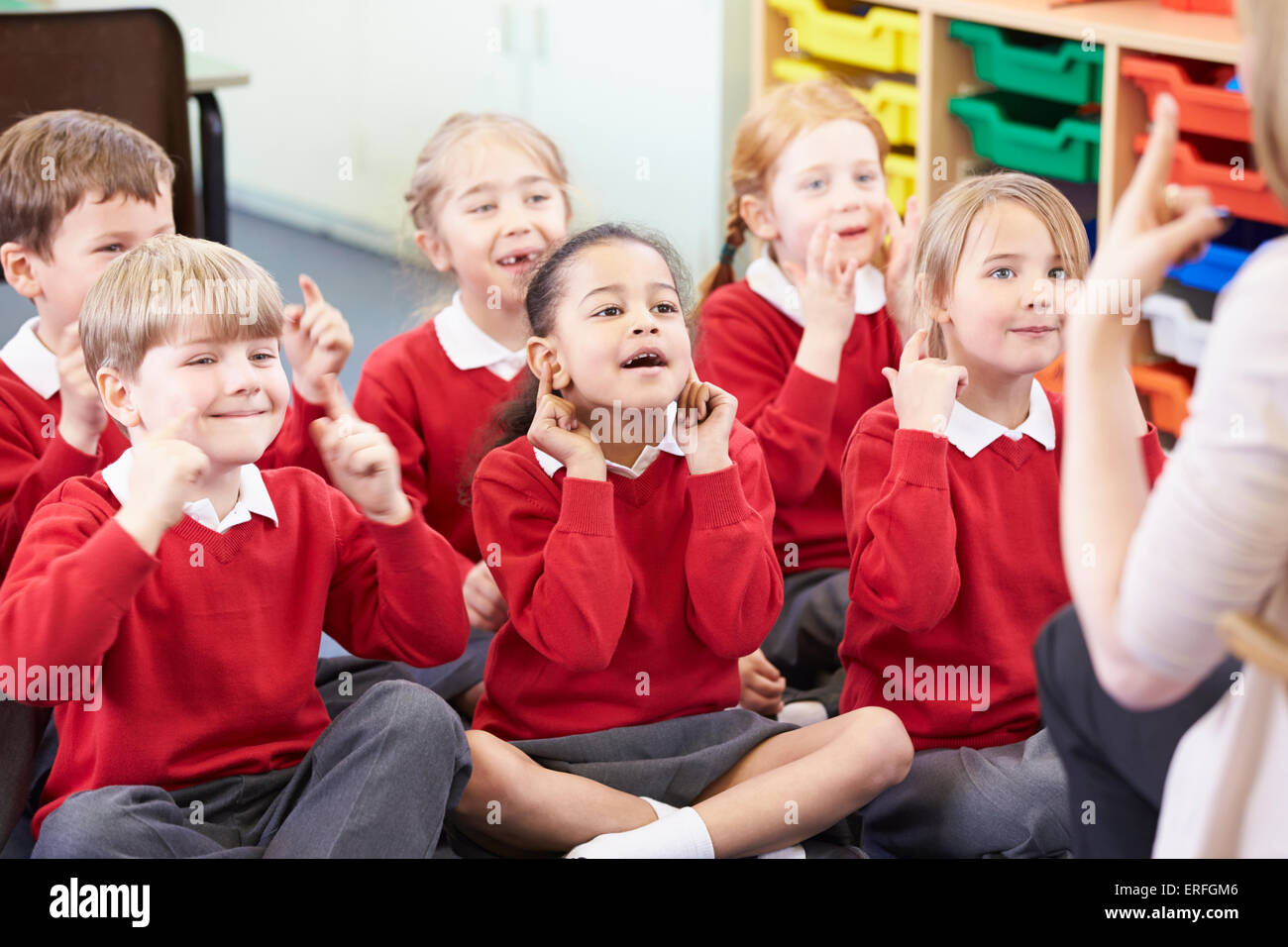 Schülerinnen und Schüler Kopieren des Lehrers Aktionen während Lied singen Stockfoto
