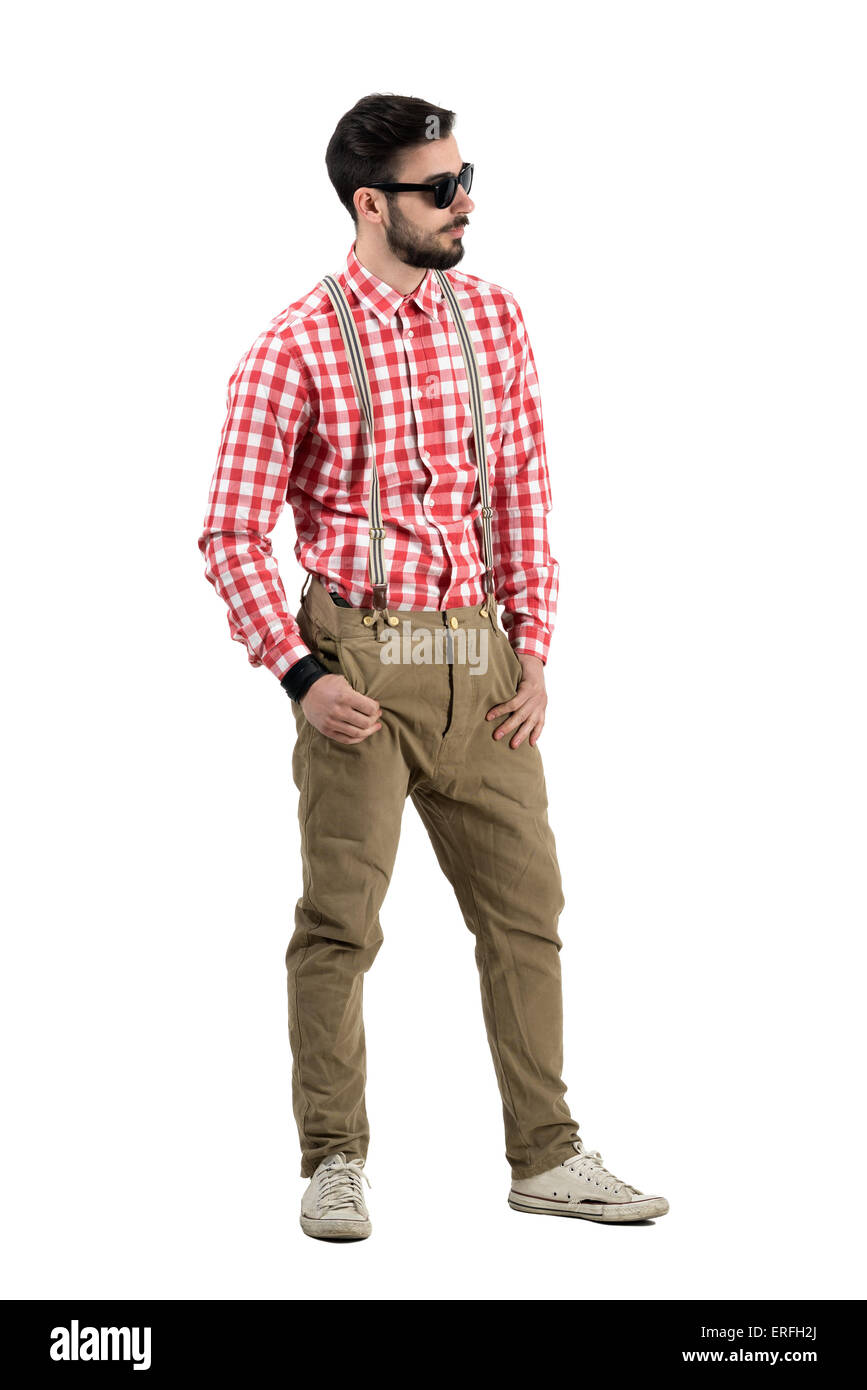 Junge bärtige Hipster mit Daumen in Taschen wegsehen. Ganzkörper-Länge-Porträt isoliert auf weißem Hintergrund. Stockfoto