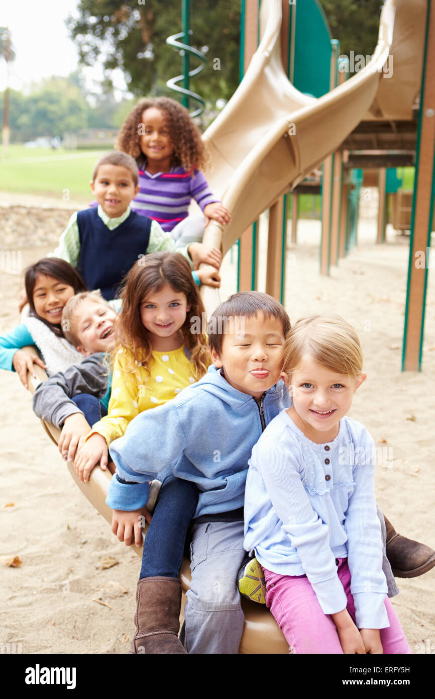 Gruppe von Kleinkindern sitzen auf Folie auf Spielplatz Stockfoto