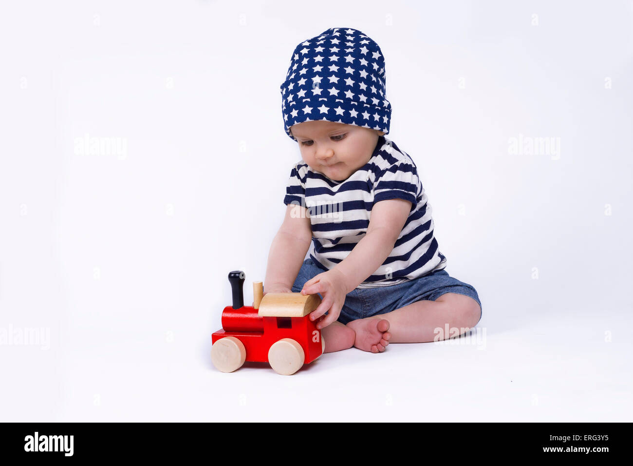 niedliche Baby spielt mit einem roten Zug Stockfoto
