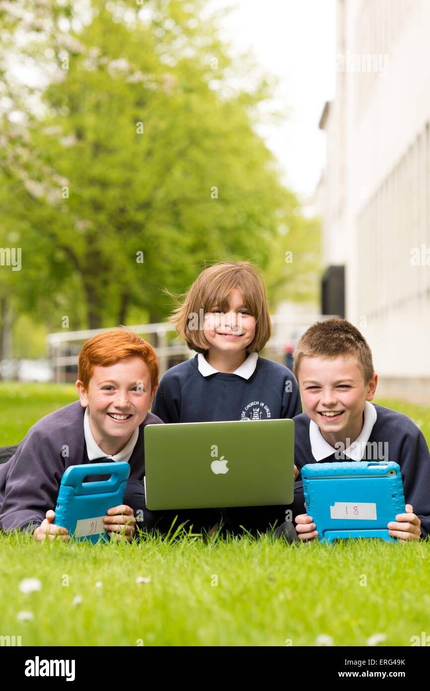 Schülerinnen und Schüler lernen über Technik und Computer während außen mit Laptops. Stockfoto