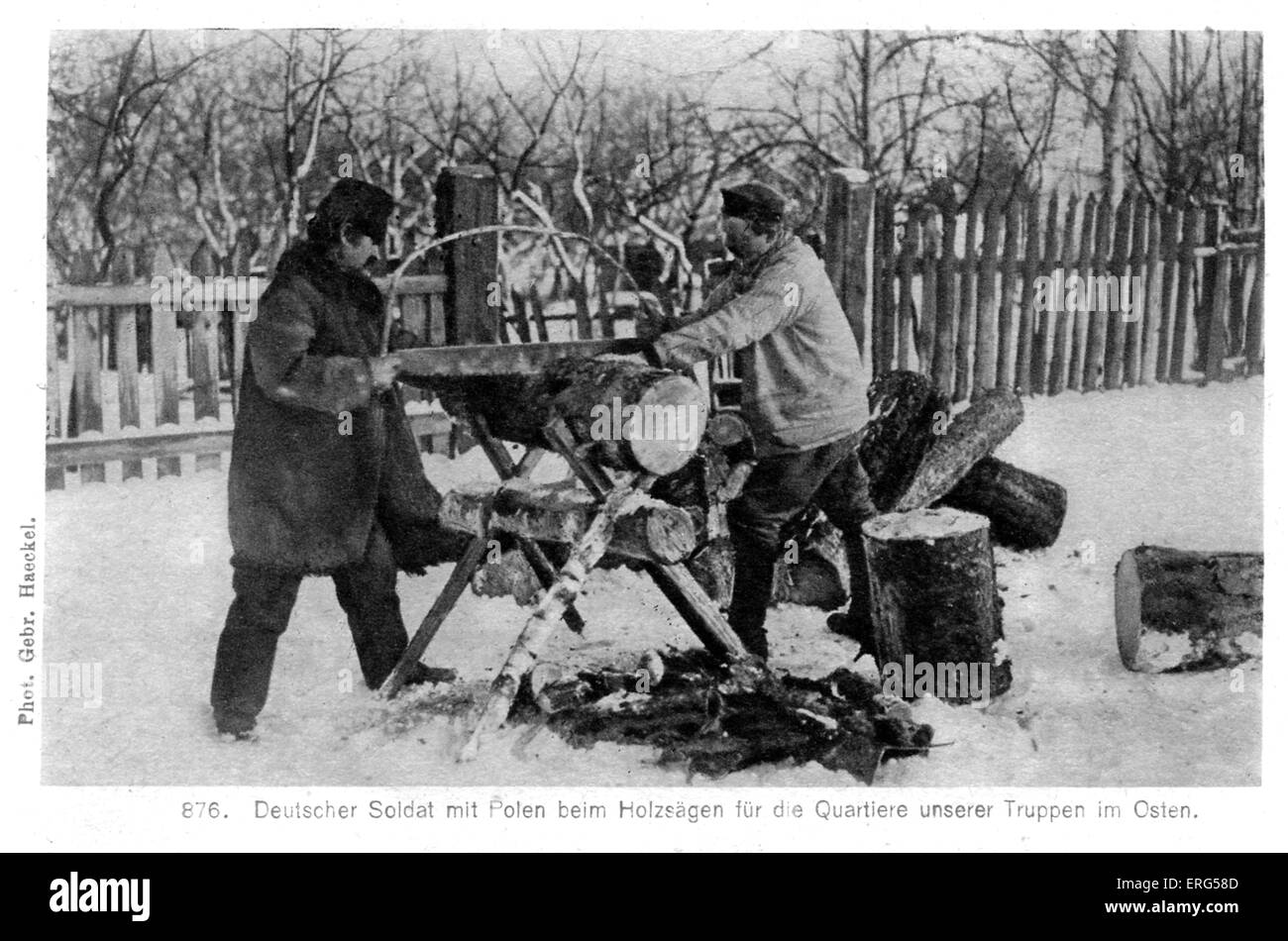 Deutsche Besetzung an der Ostfront im ersten Weltkrieg. Ein deutscher Soldat und mit einem polnischen Mann sah Holz für die deutsche Kaserne im Osten. Es liegt Schnee auf dem Boden. Bildunterschrift lautet: "Deutscher Soldat Mit Polen Beim Holzsägen Für Die Quartiere Unserer Truppen Im Osten." / "Ein deutscher Soldat und ein polnischer Mann sah Holz für unsere Soldaten Viertel im Osten." (wahrscheinlich heutigen Polen) Von "Unter Deutscher Besatzung" / "Unter deutscher Besatzung" Kollektion Stockfoto