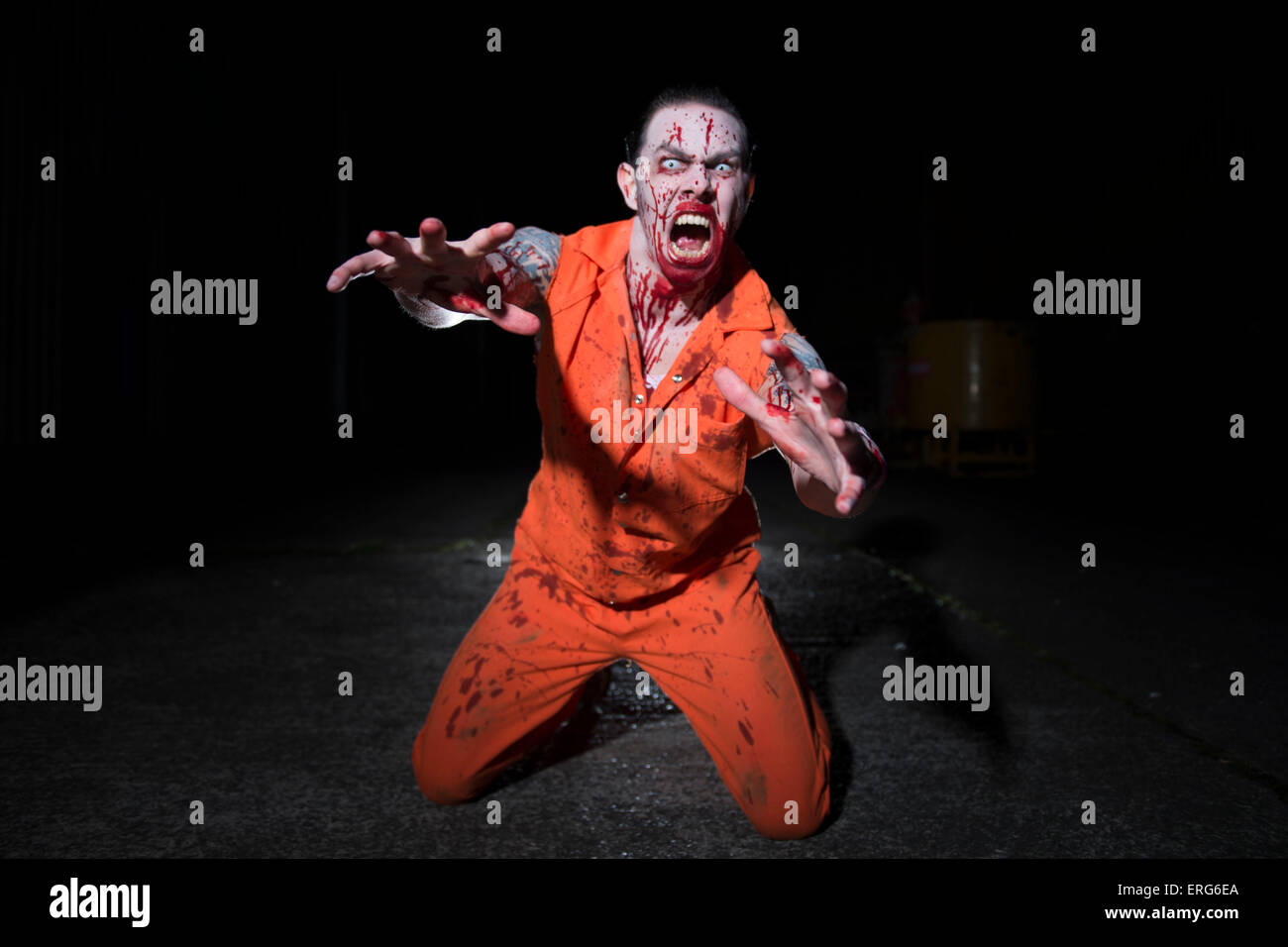 Einen männlichen Zombie Gesicht spritzte mit Blut, auf die Knie. Stockfoto