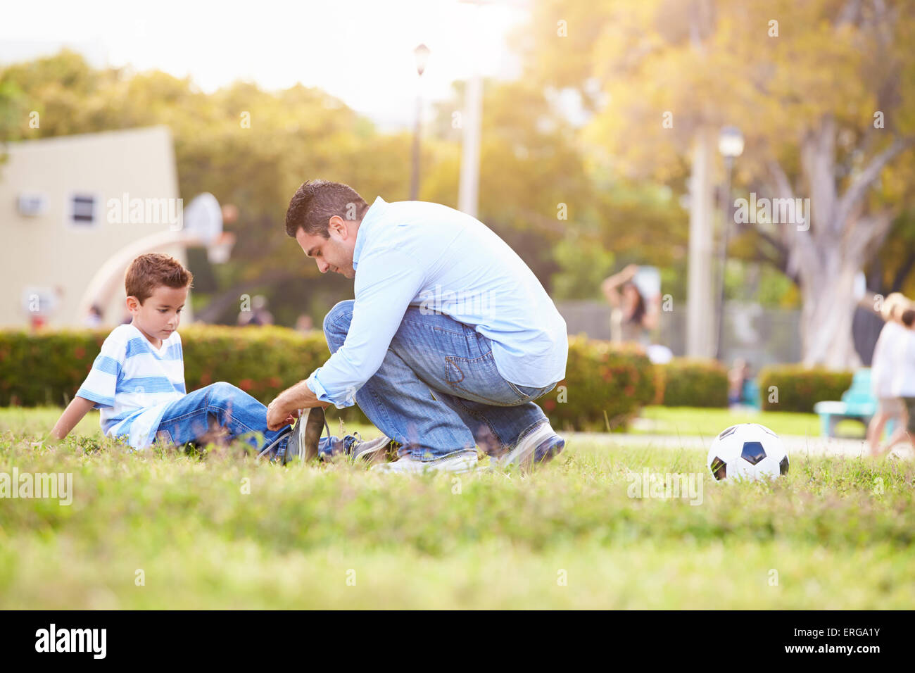 Vater auf der Suche nach dem Sohn verletzt spielen Fußball Stockfoto