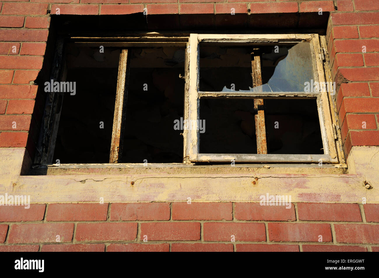 Das zerbrochene Glas in alten rostigen Fensterrahmen von verlassenen baufälligen Gebäude mit schweren Verwitterung Stockfoto