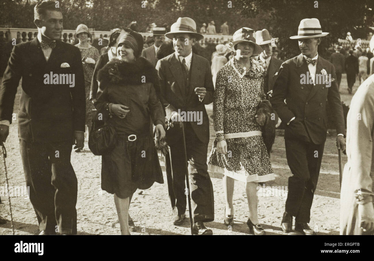 Männer und Frauen Mode 1923. Eine Gruppe nimmt einen Nachmittagsspaziergang möglicherweise in Paris? Die Männer tragen Anzüge mit Bowties und Hüte Stockfoto