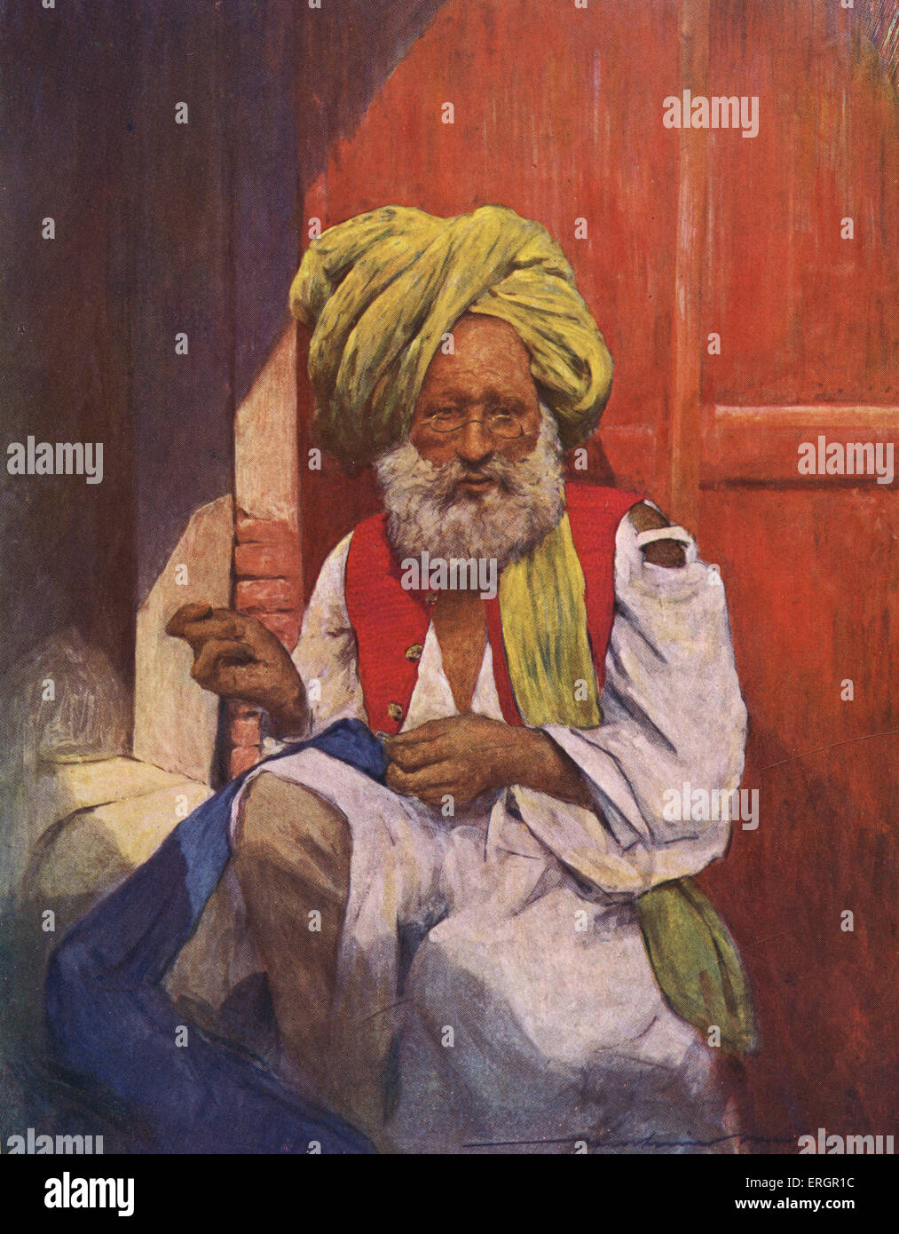 Eine indische Schneider, trug einen langen, fließenden Turban und bunten Weste, sitzt mit einer Nadel und Faden arbeiten. Stockfoto